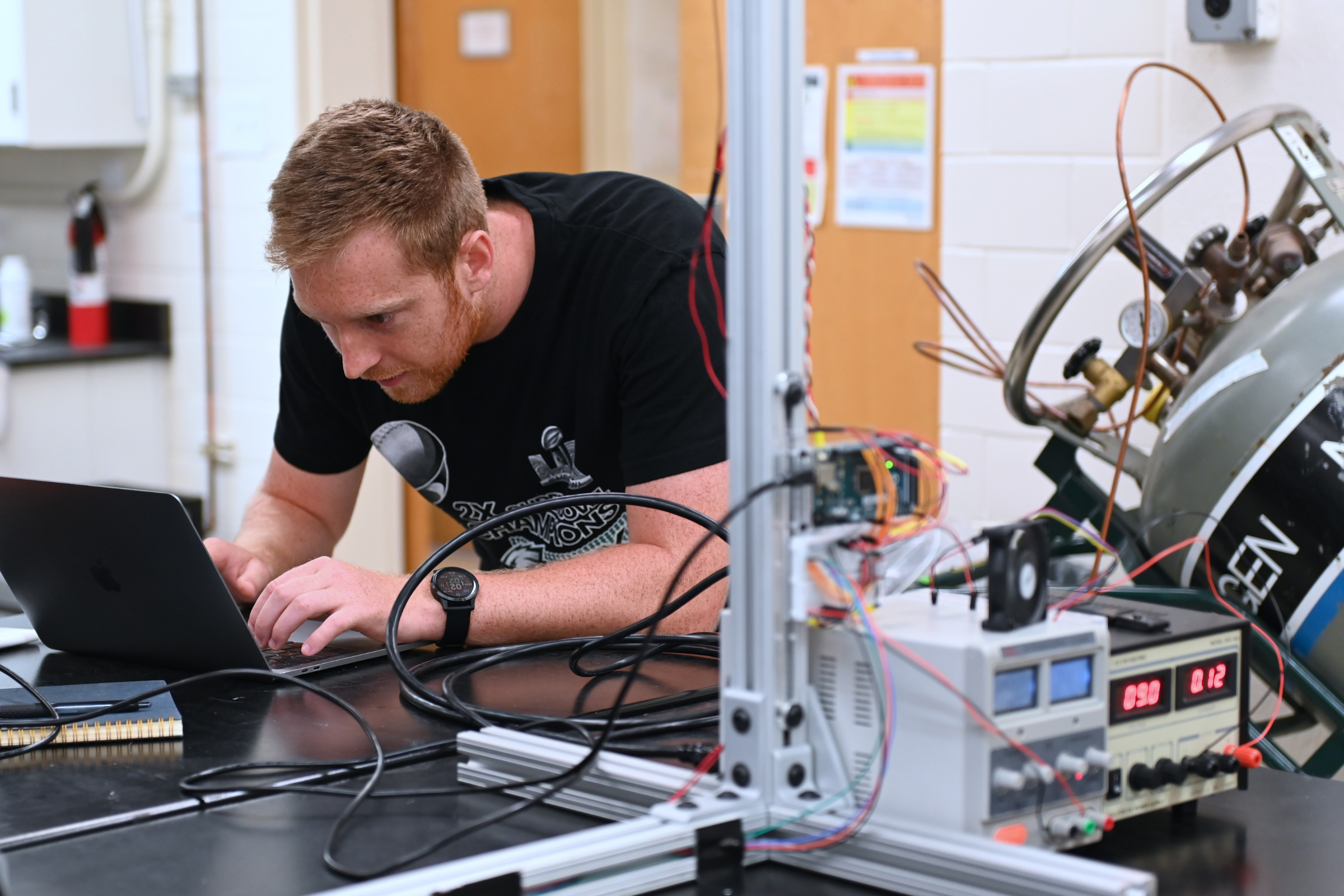 John McGrath at a lab bench with machinery 